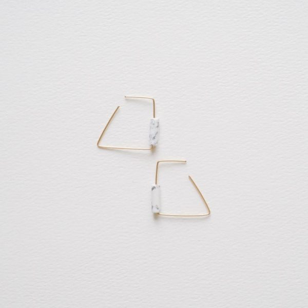 This pair of hoop earrings uses hand contoured wires featuring white turquois natural stones. Sleek earrings with clean geometric lines and a bright flash of colour. 