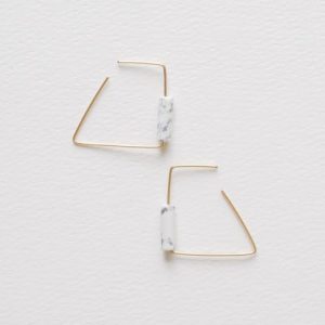 This pair of hoop earrings uses hand contoured wires featuring white turquois natural stones. Sleek earrings with clean geometric lines and a bright flash of colour. 